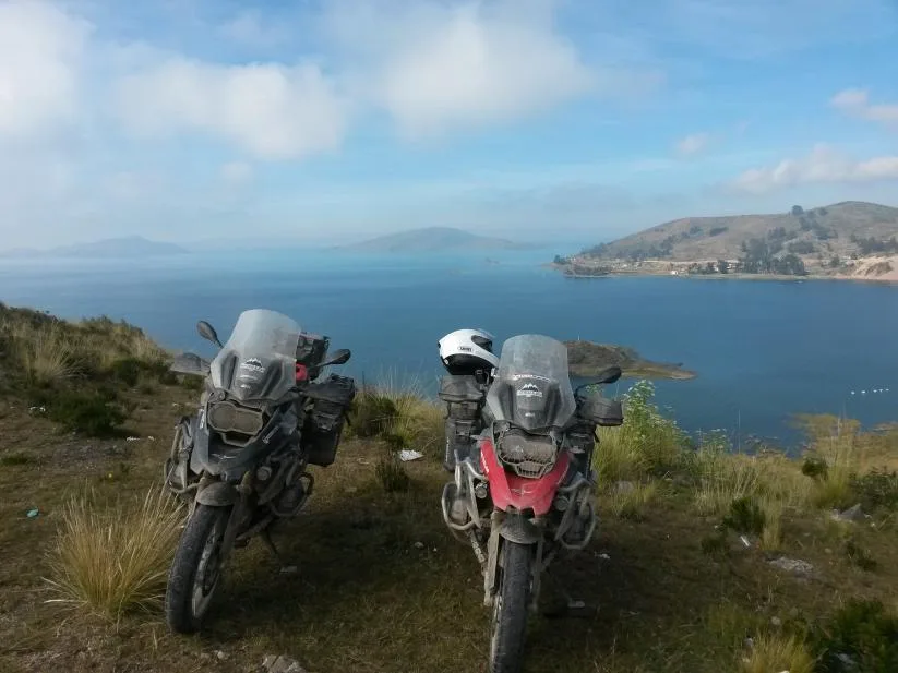 Duas motocicletas estacionadas em frente ao lago azul.