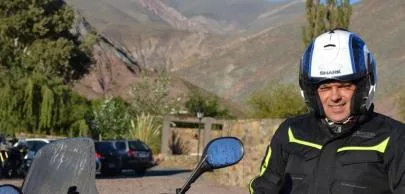 eb1d7003c8e6df756d2d2496e82e364b482d70a1 Homem de capacete em frente a montanhas e vegetação.