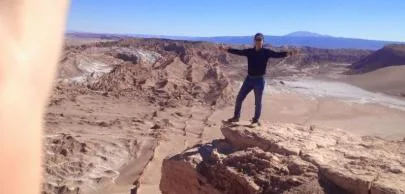eb1d7003c8e6df756d2d2496e82e364b482d70a1 Pessoa em pé no deserto com braços abertos.