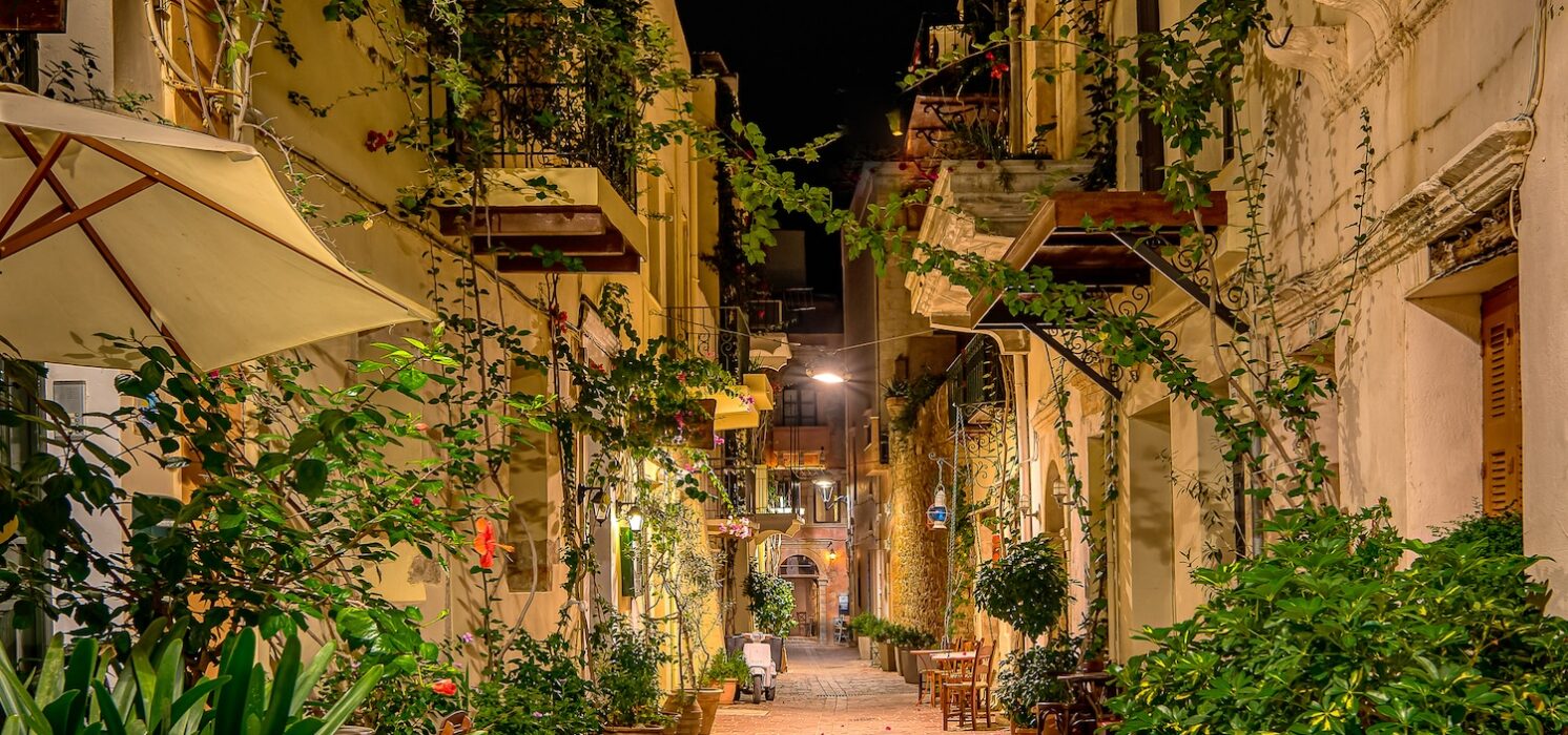 The illuminated alley Antoni Gampa with green plants and balconies in the old town of Chania