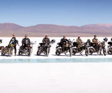eb1d7003c8e6df756d2d2496e82e364b482d70a1 Grupo de motociclistas em salinas com montanhas ao fundo.
